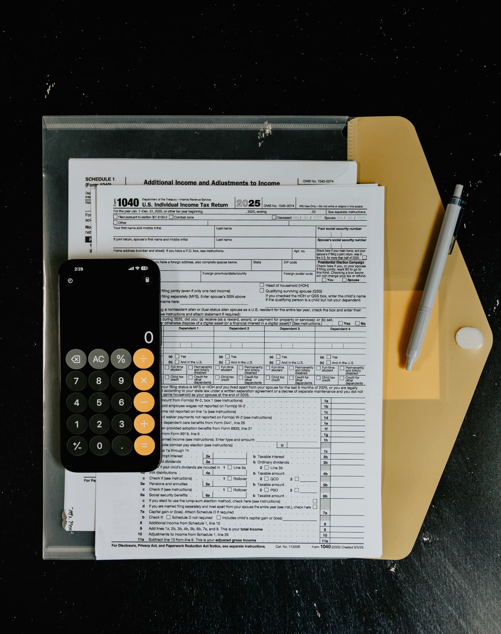 Tax forms and calculator arranged on a desk.