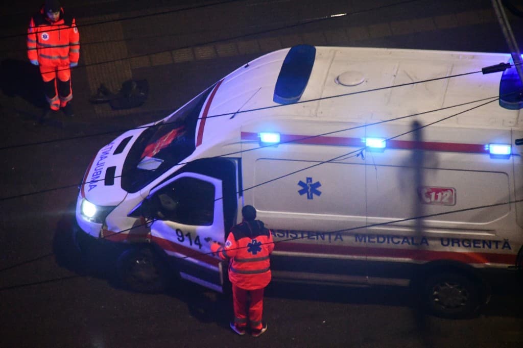 Nighttime emergency response scene around an ambulance.